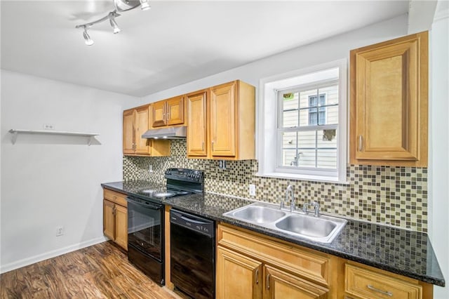 kitchen with dark wood-style floors, dark countertops, a sink, under cabinet range hood, and black appliances