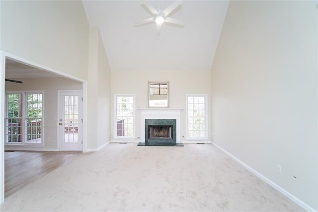 unfurnished living room featuring a healthy amount of sunlight, ceiling fan, and high vaulted ceiling