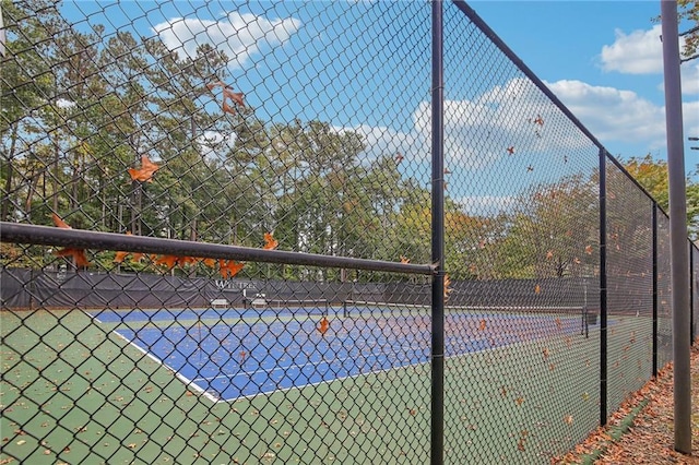 view of tennis court featuring fence