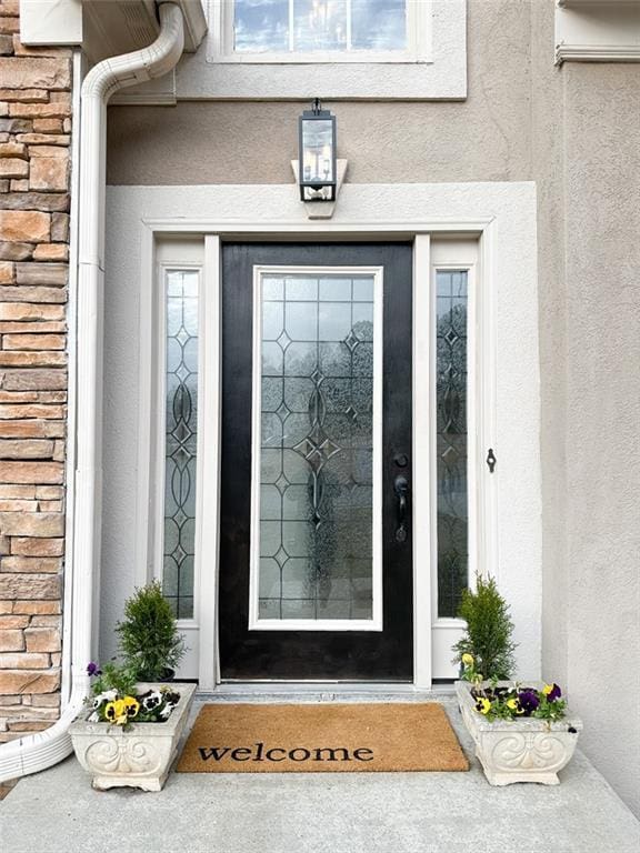 doorway to property with brick siding and stucco siding