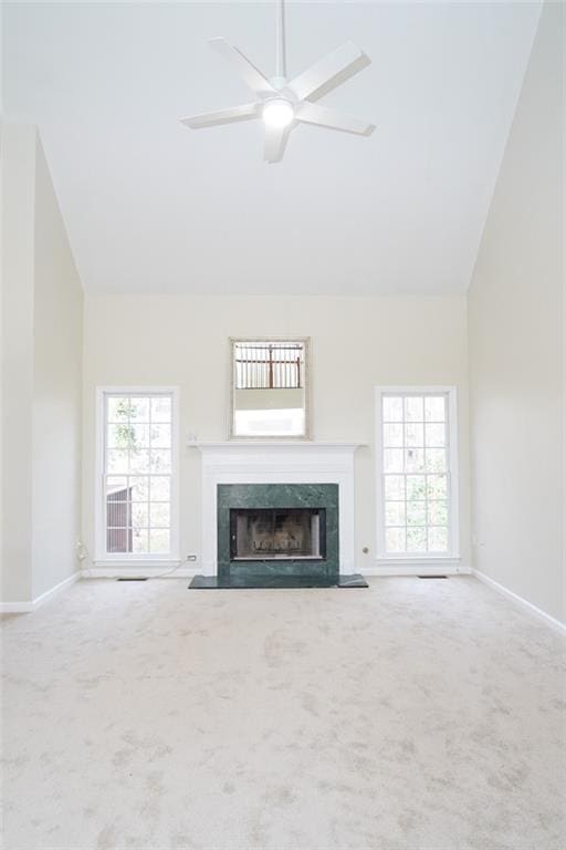 unfurnished living room with carpet, baseboards, ceiling fan, and a high end fireplace