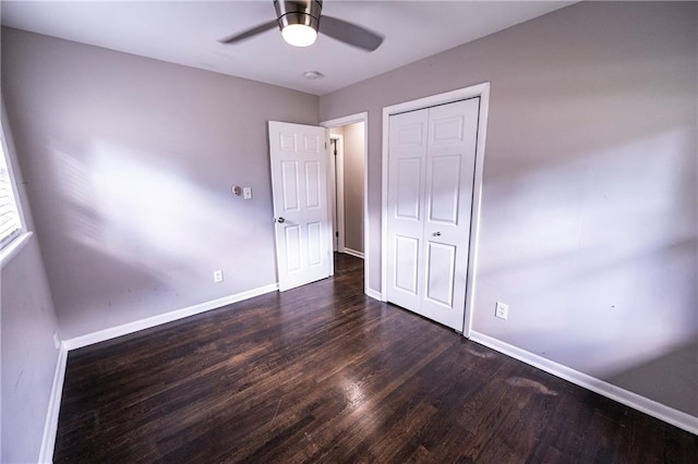 unfurnished bedroom with ceiling fan, a closet, and dark hardwood / wood-style flooring