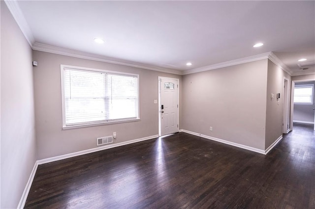 foyer entrance with ornamental molding and dark hardwood / wood-style flooring