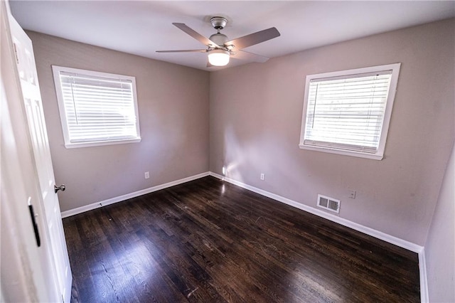 empty room with dark hardwood / wood-style floors and ceiling fan