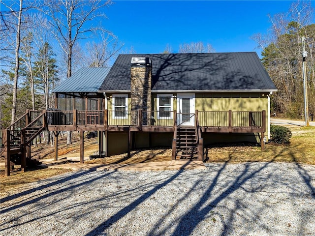 exterior space featuring metal roof, a chimney, stairway, and a deck