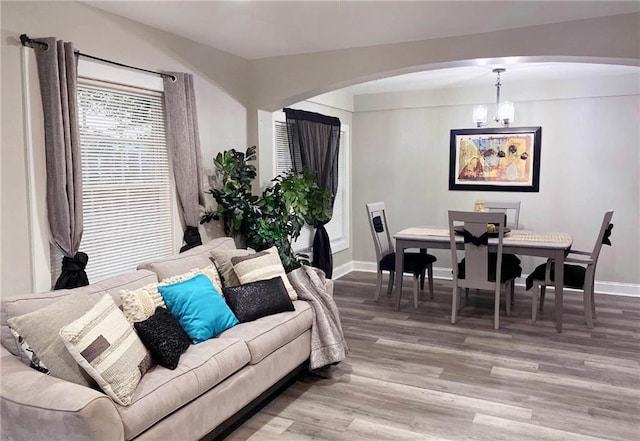 3046 Dobbs Way, East Point, GA 30344 - living room featuring arched walkways, light wood-style flooring, baseboards, and a chandelier