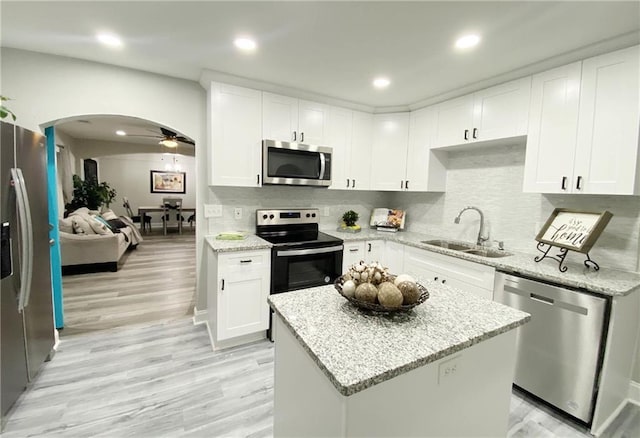 3046 Dobbs Way, East Point, GA 30344 - kitchen featuring appliances with stainless steel finishes, a sink, arched walkways, white cabinets, and recessed lighting