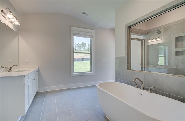 18 Slick Ct, Senoia, GA 30276 - full bathroom featuring a freestanding bath, vanity, vaulted ceiling, and tile patterned floors
