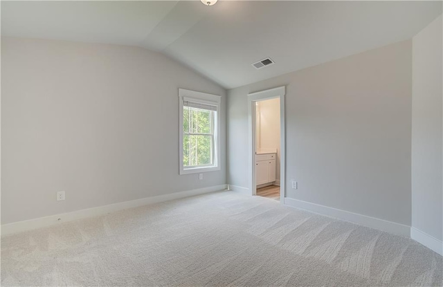 18 Slick Ct, Senoia, GA 30276 - unfurnished bedroom featuring vaulted ceiling, light carpet, and connected bathroom