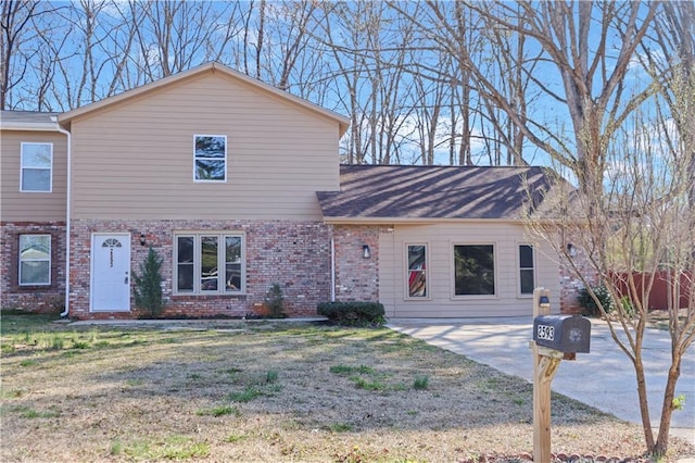 view of front of property featuring brick siding and a front lawn