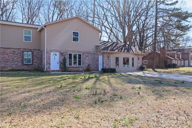 view of front of property with a front lawn and brick siding