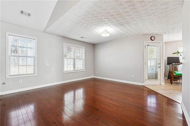 empty room featuring a textured ceiling and hardwood / wood-style floors