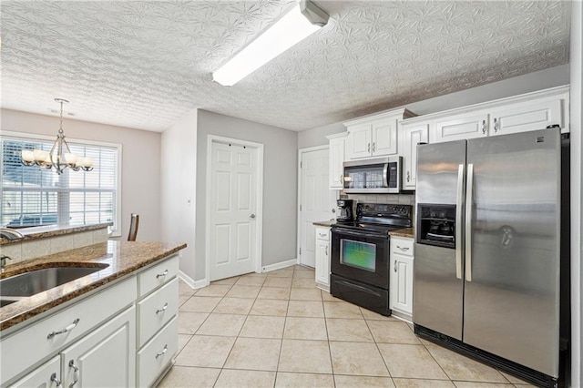 kitchen featuring stainless steel appliances, light tile patterned flooring, stone countertops, white cabinets, and sink