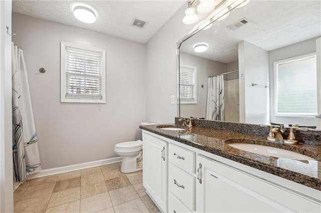 bathroom with toilet, vanity, a textured ceiling, and curtained shower