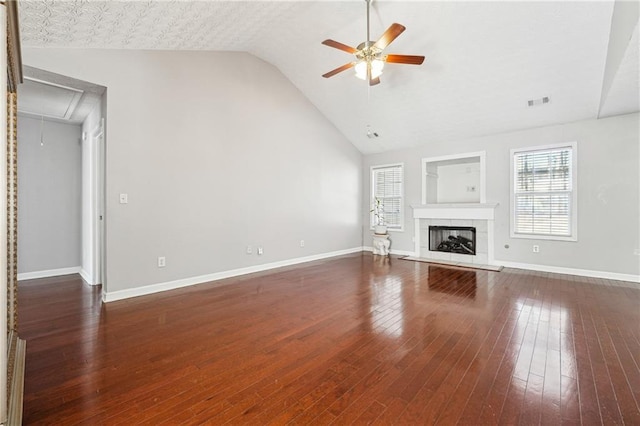 unfurnished living room with ceiling fan, dark wood-type flooring, a healthy amount of sunlight, and a fireplace