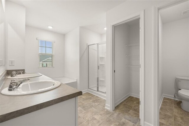 bathroom with a shower with shower door, vanity, and toilet