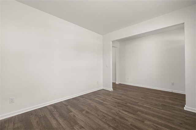 spare room with dark wood-type flooring