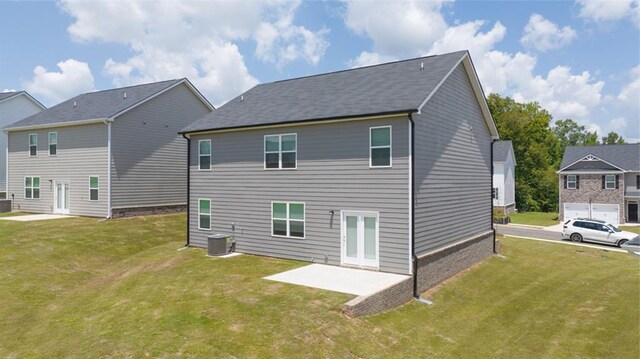 back of property with a lawn, central AC, and a patio area