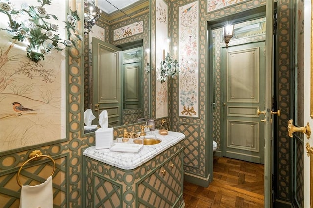 bathroom featuring vanity, parquet floors, and toilet