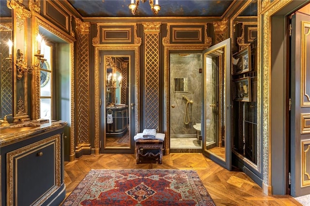 interior space with toilet, ornamental molding, a shower with shower door, parquet flooring, and vanity