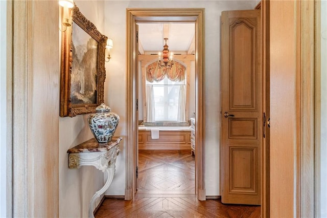 hallway featuring parquet flooring and a chandelier