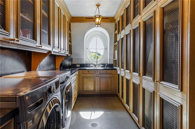 washroom featuring cabinets, washer and clothes dryer, and ornamental molding