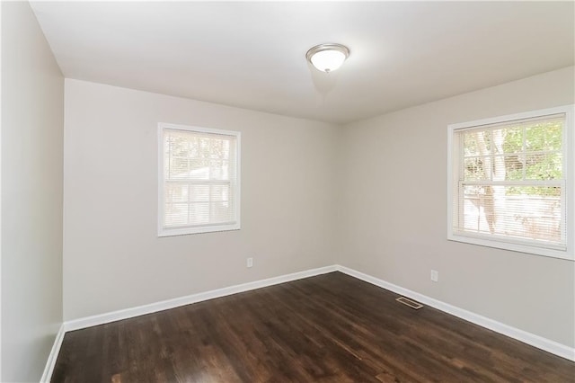 spare room with dark hardwood / wood-style flooring