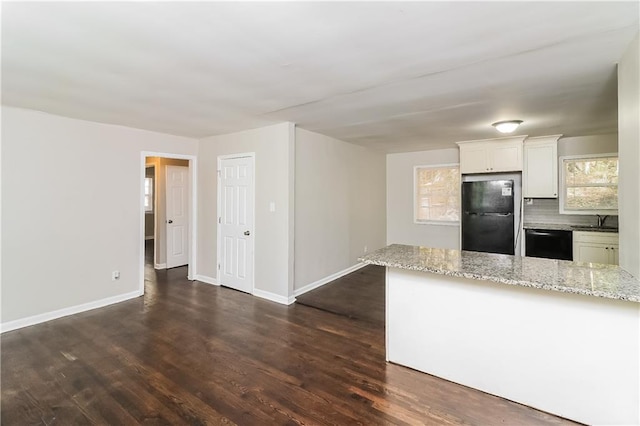 kitchen featuring white cabinetry, sink, light stone counters, dark hardwood / wood-style floors, and black appliances