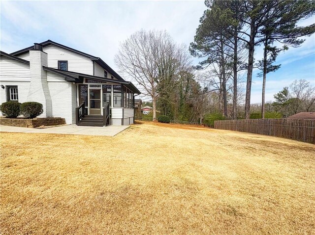 2167 Cedar Dr, Lawrenceville, GA 30043 - view of yard with entry steps, fence, a patio, and a sunroom