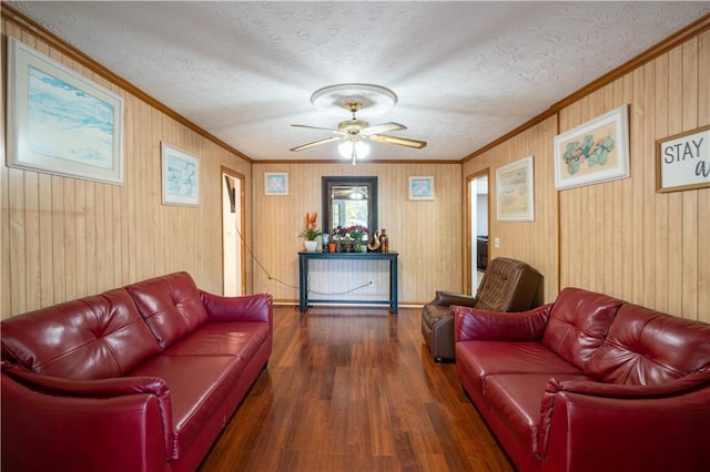 living room with dark hardwood / wood-style flooring, ornamental molding, ceiling fan, and a textured ceiling