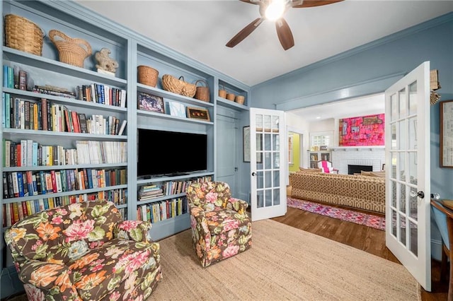 626 Elmwood Dr NE, Atlanta, GA 30306 - living area with french doors, ornamental molding, wood finished floors, ceiling fan, and a brick fireplace