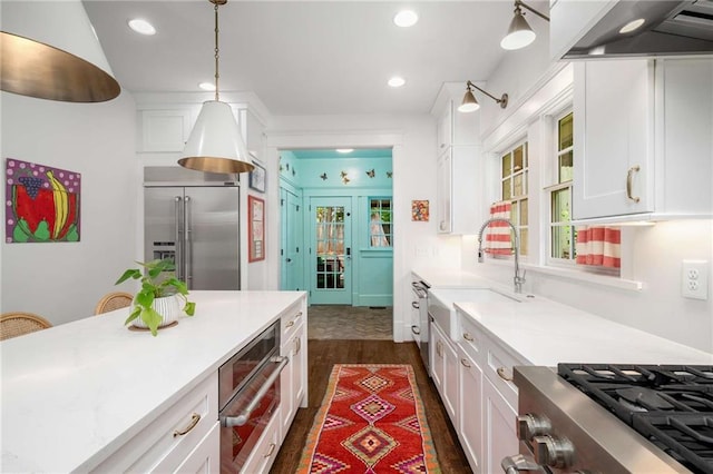 626 Elmwood Dr NE, Atlanta, GA 30306 - kitchen featuring appliances with stainless steel finishes, wall chimney exhaust hood, white cabinets, light countertops, and dark wood-style flooring