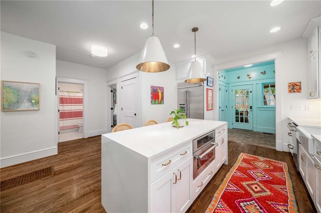 626 Elmwood Dr NE, Atlanta, GA 30306 - kitchen featuring stainless steel appliances, dark wood-style floors, light countertops, white cabinets, and a center island