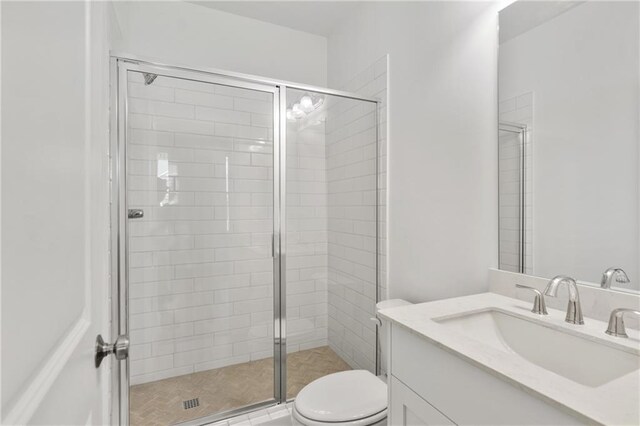 full bathroom featuring toilet, vanity, and a stall shower
