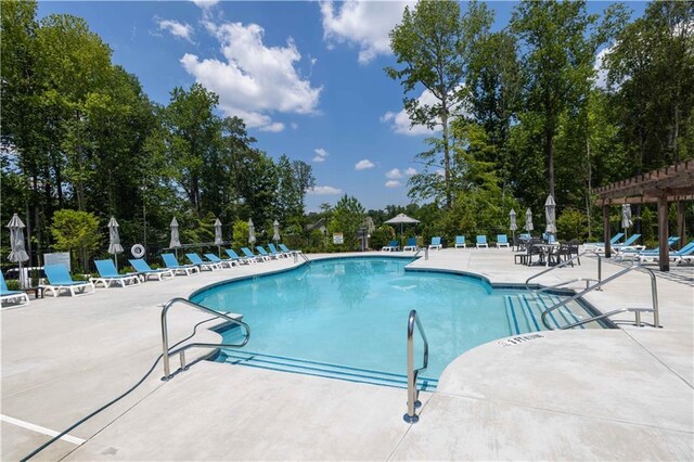 community pool with a pergola and a patio