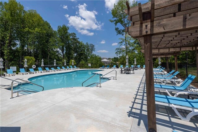 community pool featuring fence and a patio area