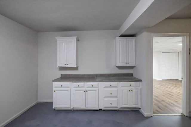 2010 Riverside Rd, Roswell, GA 30076 - kitchen with baseboards, white cabinetry, and dark countertops