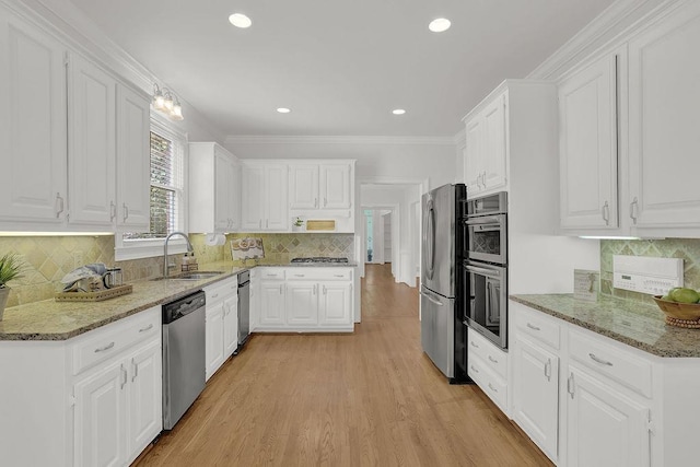 2010 Riverside Rd, Roswell, GA 30076 - kitchen featuring appliances with stainless steel finishes, a sink, backsplash, white cabinets, and light stone counters