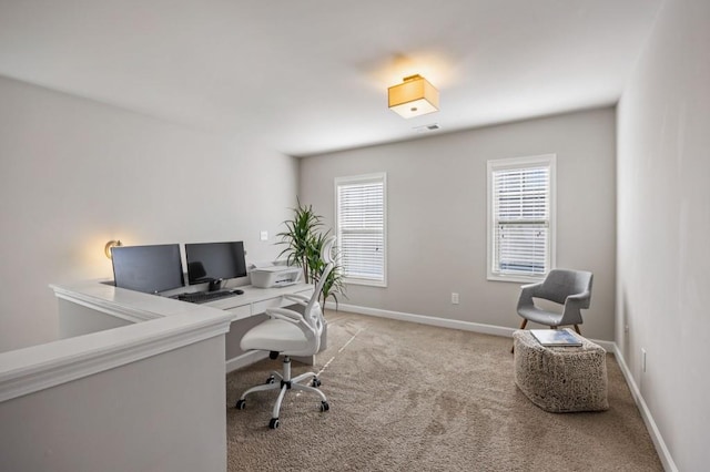 carpeted home office featuring baseboards, plenty of natural light, and visible vents