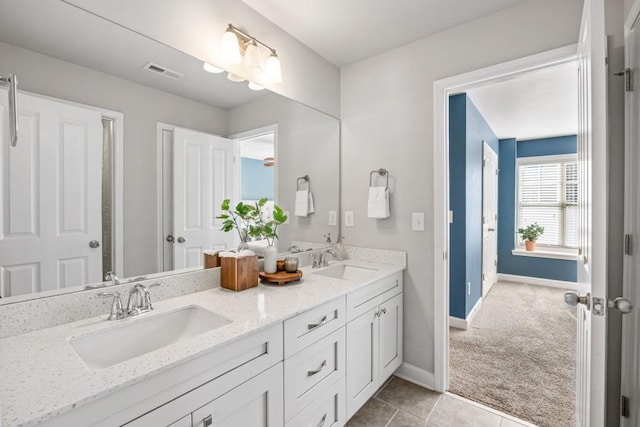 bathroom featuring baseboards, visible vents, and a sink