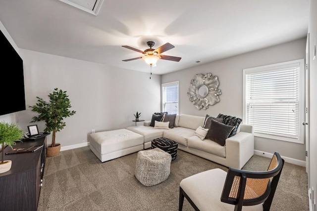 carpeted living room featuring attic access, visible vents, baseboards, and ceiling fan