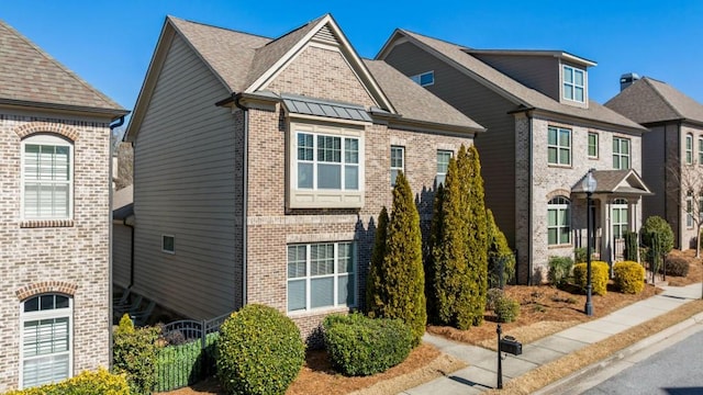 view of front of house with brick siding and a shingled roof