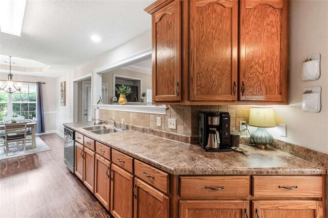 102 Blackstone Ct, Kathleen, GA 31047 - kitchen featuring dishwasher, a sink, brown cabinets, backsplash, and a textured ceiling