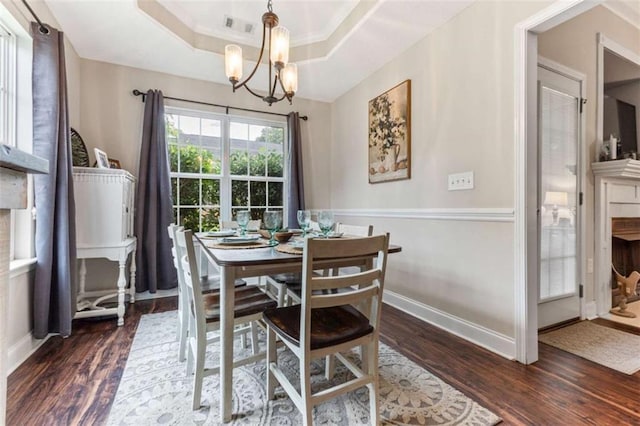 102 Blackstone Ct, Kathleen, GA 31047 - dining area with dark wood-style flooring, a chandelier, a raised ceiling, and baseboards
