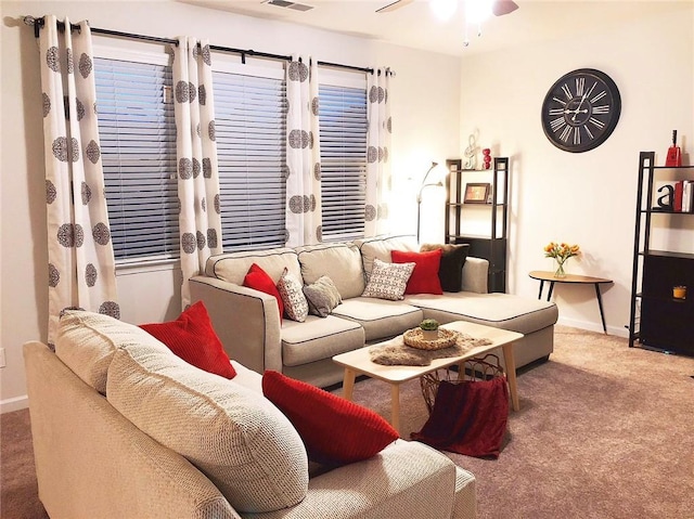 living room with carpet floors, visible vents, ceiling fan, and baseboards