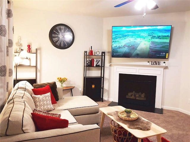 carpeted living area featuring a fireplace with flush hearth, baseboards, and a ceiling fan