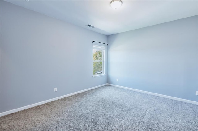 spare room with carpet, visible vents, and baseboards