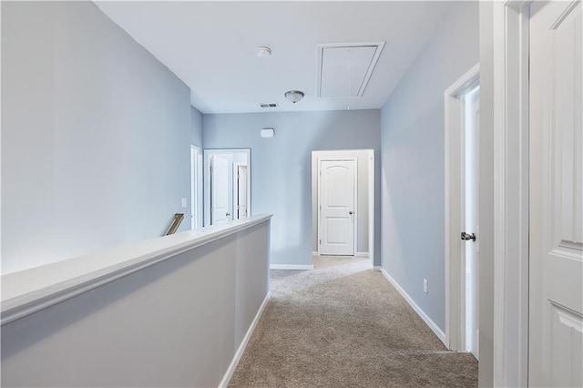 hall featuring light carpet, visible vents, an upstairs landing, baseboards, and attic access