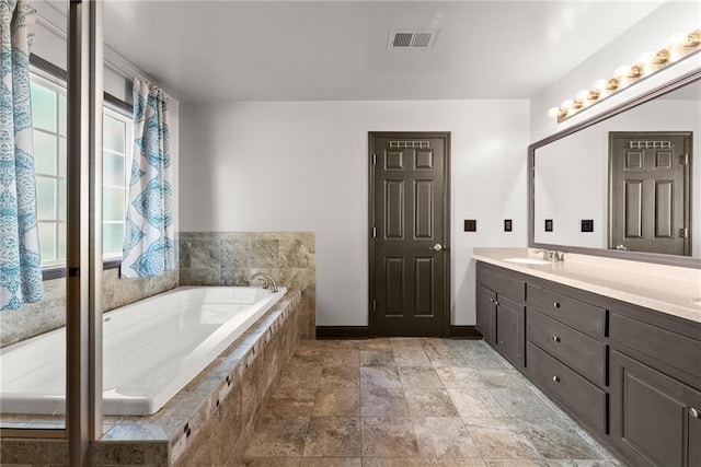 5995 Wellington Ave, Gainesville, GA 30506 - bathroom with plenty of natural light, double vanity, a bath, and baseboards