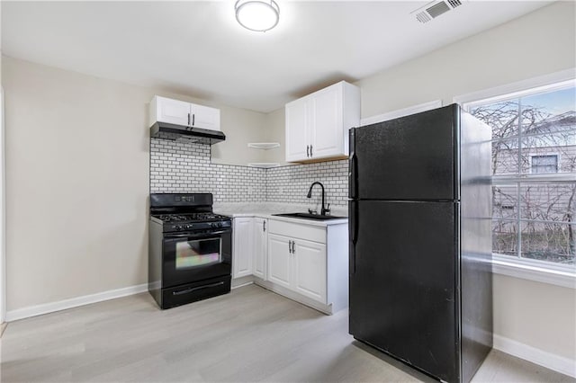 kitchen featuring sink, white cabinets, backsplash, and black appliances